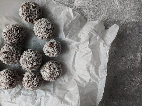 Close-up of chocolate coconut balls on crinkled parchment, highlighting texture.